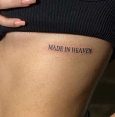 a woman's stomach with the words made in heaven tattooed on her lower back