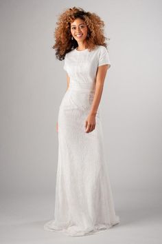 a woman in a white wedding dress posing for the camera with her hair blowing back