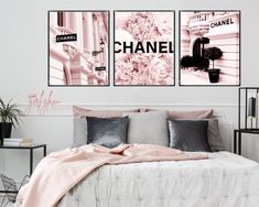 two posters on the wall above a bed in a room with pink and grey decor