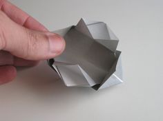 a person is holding an origami object in their hand