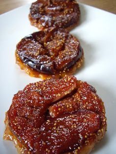 three pastries on a white plate sitting on a table