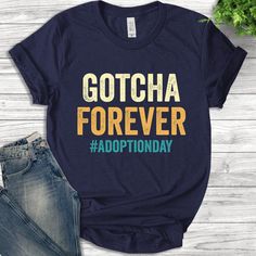 a t - shirt with the words gotcha forever on it next to some jeans