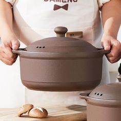 a person wearing an apron holding a pot