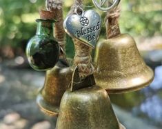 three bells are hanging from twine with the words blessing and heart on one end