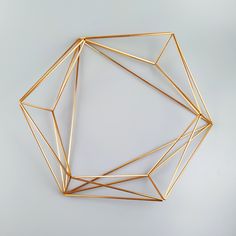 a gold geometric object on a white surface