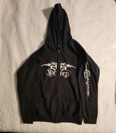 a black zip up hoodie with white writing on it