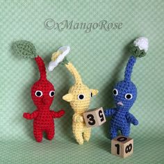 three crocheted toys are standing next to each other with numbers on them and one is holding a tennis racquet