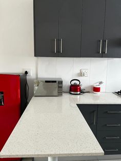 a red refrigerator sitting in the middle of a kitchen