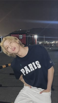 a woman posing with a baseball bat in her hand and wearing a paris t - shirt