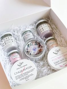 three jars of body care products in a white box with pink and blue flowers on them