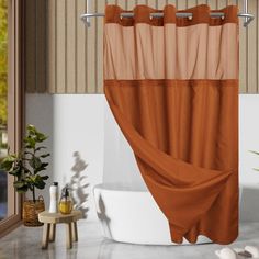 an orange and brown shower curtain in a bathroom next to a bathtub with white fixtures