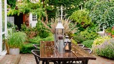 a wooden table sitting in the middle of a garden