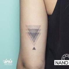 a woman's arm with a triangle tattoo on the left side of her arm