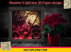 the shadow light box 3d paper design is next to a potted plant with red poinsettis