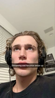 a man with headphones on looking up at the camera