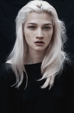 a woman with long white hair and black shirt