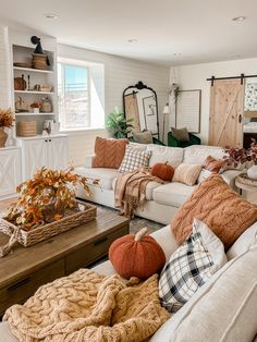 a living room filled with furniture and lots of pillows on top of it's couches