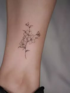 a small flower tattoo on the side of a woman's foot is shown in black and white