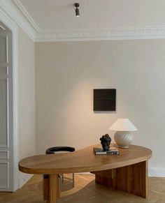 a table with a lamp on it in the middle of a room