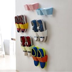 four pairs of shoes are hanging on the wall next to each other in different colors