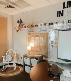 a room with a desk, chair and whiteboard