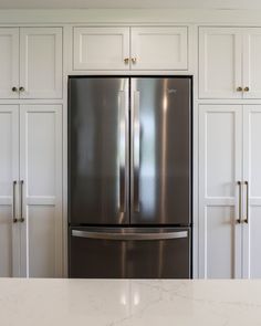 a stainless steel refrigerator in a white kitchen