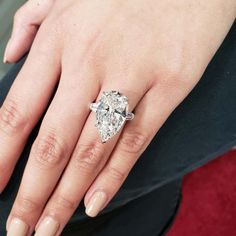 a woman's hand with a diamond ring on it