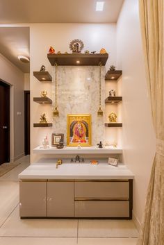 a white counter with shelves on each side and a gold framed painting above it in the middle