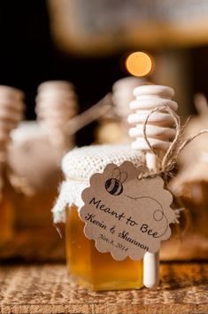 small jars filled with honey sitting on top of a wooden table