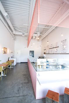 the inside of a restaurant with tables and chairs in it, along with a counter