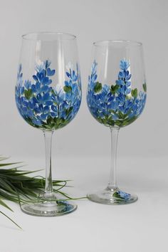 two wine glasses with blue flowers painted on them