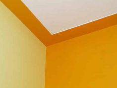 the corner of a room with an orange wall and white ceiling, painted in yellow