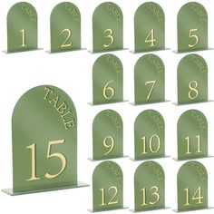 a set of twelve green and gold table numbers with arch shaped bases for each number