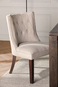 a chair sitting on top of a rug next to a table