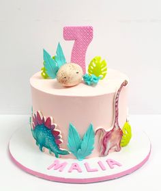 a pink cake with blue and green decorations