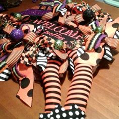 a close up of a wreath on a table with polka dots and striped ribbon decorations