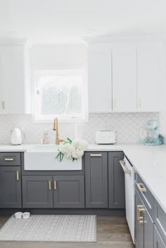 a kitchen with gray cabinets and white counter tops is featured in the video for how to decorate