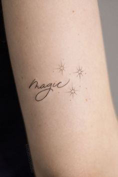 a woman's arm with the word magic written in cursive writing on it