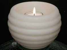 a white candle sitting on top of a black table