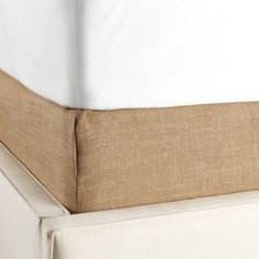 close up view of the side of a bed with white linens