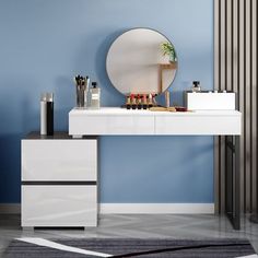 a vanity with a round mirror and various beauty products on it in front of a blue wall