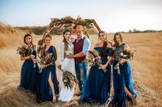 a group of people standing next to each other on top of a dry grass field