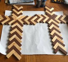 a cross made out of strips of wood sitting on top of a piece of paper