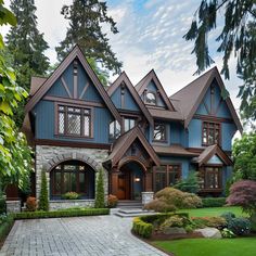 a large blue house with lots of windows and stone walkways in front of it