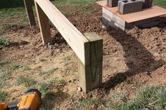 a pair of power tools sitting on top of a field next to a wooden fence