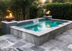 an outdoor swimming pool surrounded by landscaping