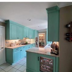 a kitchen with blue cabinets and white tile flooring, including a wine rack on the wall