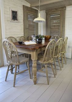 a dining room table with six chairs and a lamp hanging over the top of it