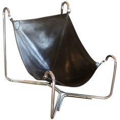 a black leather chair with metal frame and footrests on it's side