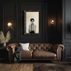 a living room with black walls and leather couches in front of a framed portrait